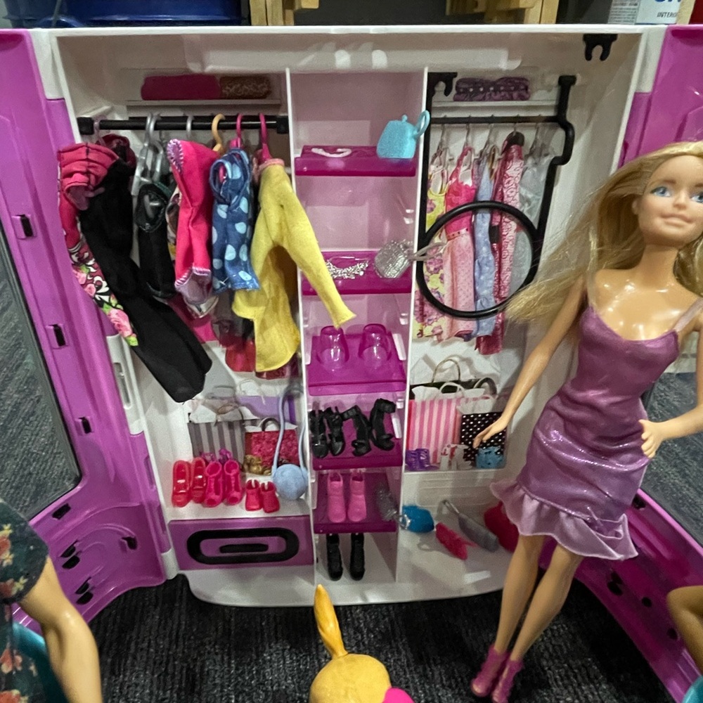 Barbie player with closet, accessories and multiple Barbie figures.